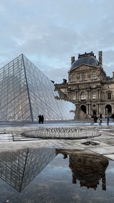 people are standing in front of the glass pyramid