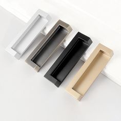 three different types of drawer pulls on a white surface, one black and one gold