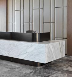 a marble reception desk in front of a wall