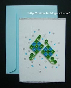 two green and blue pieces of paper on top of a white card next to a blue envelope