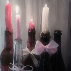 three wine bottles with candles in them sitting next to each other