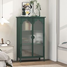 a bedroom with a green cabinet next to a bed