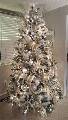 a decorated christmas tree with silver and white ornaments