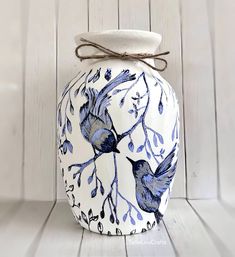 a blue and white vase with two birds on it