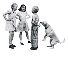 three children and a dog standing next to each other in front of a white background