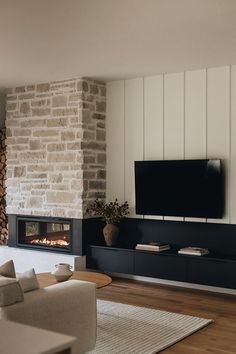 a living room with a fireplace and tv on the wall, in front of it