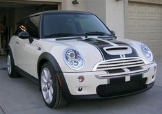 a white and black car parked in front of a garage