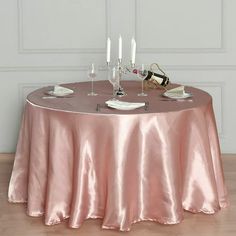 the table is set with wine glasses and plates on it, along with two champagne flutes