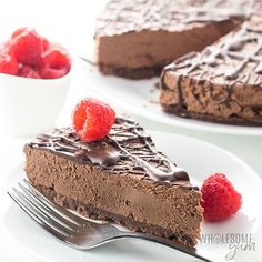 a slice of chocolate cheesecake on a plate with raspberries next to it