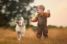 a little boy and his dog running through the grass together in an outdoor photo shoot