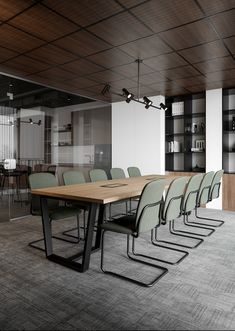 an empty conference room with green chairs and a wooden table in front of the wall