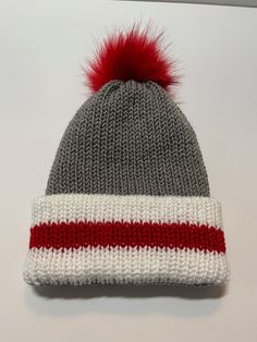 *This is an Addi Express knitted beanie made in soft acrylic yarn. *Beanie is double layered and reversible with a removable pom-pom.   *The beanie fits an older teen and average adult. * All of my handmade items come from a non-smoking home.   *Sales are final. *Ready to ship. Care Instructions: Remove pom-pom and hand-wash.  Line air dry. Note:  If you would like an item made to order, feel free to contact me. THANK YOU for supporting my small business 😊. Red Bonnet For Winter, One Size Fits Most, Red Beanie For Cold Weather, Red Winter Bonnet (one Size Fits Most), Red Winter Bonnet, One Size Fits Most, Red Winter Beanie, One Size Fits Most, Red Winter Beanie One Size Fits Most, Red Knitted Hat For Cold Weather, Red Knitted Beanie For Winter, Red Knitted Winter Beanie