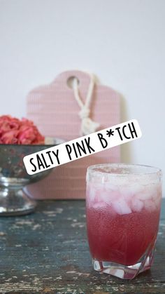 a pink drink sitting on top of a wooden table