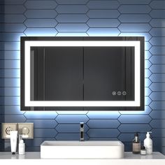 a bathroom with a sink, mirror and soap dispenser on the wall