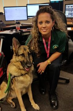 a woman sitting next to a dog in an office