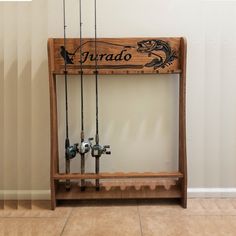 a wooden shelf with fishing rods and hooks on it in front of a white wall