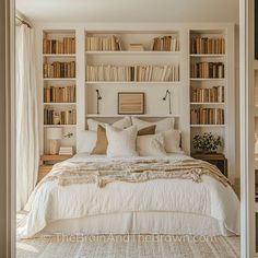 a bedroom with bookshelves and a bed in the middle is decorated with white linens