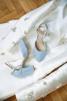 a pair of blue shoes sitting on top of a white dress