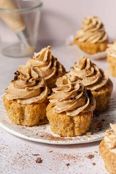 several cupcakes with frosting on a plate