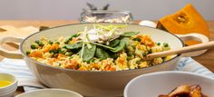 a bowl filled with rice and vegetables on top of a table next to other bowls