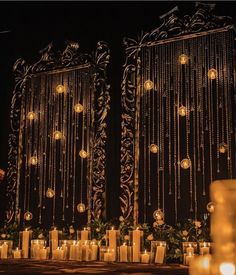 candles are lit in front of an elaborately decorated building with glass balls hanging from it