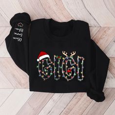 Gigi Claus Christmas lights And Grandkids Christmas Merry Sweatshirt This sweatshirt is perfect to escape the cold. It covers everything from the hips to the neck, allows the person wearing it to stay toasty at all times. Plus, with the side-front pockets, the phone and the wallet can stay warm, too. 1. Nickname. ie. Grandma, Nana, Mimi, ...etc. 2. Kids' Names wanted on the shirt (Names separated by commas) All items are made to order. * Please be aware that the physical product's colors may differ slightly from the mockup. Suitable for many occasions, such as for Valentine, Christmas, Father's Day, Mother's Day, Birthday,... 8.0 oz., pre-shrunk 65/35 cotton/polyester Blend pill-resistant fleece Two-ply hood with grommet Front pouch pocket Seamless body with set-in sleeves 1x1 rib cuffs an Gigi Christmas Shirt, Merry Sweatshirt, Gifts For Nana, Christmas Gift For Grandma, Shirt Names, Christmas Gifts For Grandma, Kids Names, Nana Gifts, Gift For Grandma