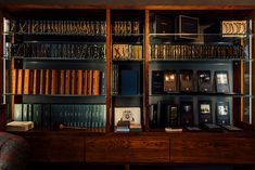 a book shelf with many books on it and a chair in front of the shelves