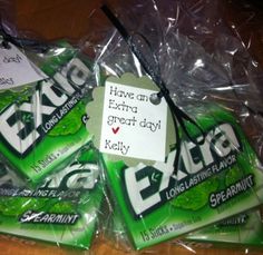 several chewing gums wrapped in plastic on top of a wooden table next to a sign that says, have an extra great day kelly