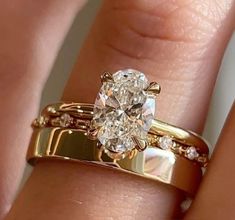 a close up of a person's hand with a gold ring and diamond set