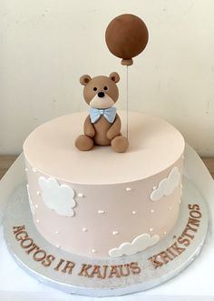 a birthday cake with a teddy bear holding a balloon