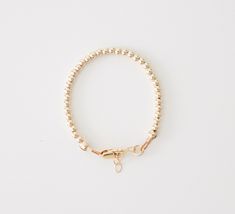 "This baby bracelet is made with high quality 14k gold filled beads, lobster clasp, and extender that won't tarnish and will resist most wear and tear, with the right care. We highly recommend measuring your babies wrist for the best fit. Take a measuring tape and measure wrist tightly around (in inches). Add 1/2 inch and that's the size you should order. Each bracelet comes with extra links that extend 1/2 inch beyond the size you order. If you are buying as a gift, this chart is a good guideli Adjustable 14k Gold Bracelet With Gold Beads, Adjustable 14k Gold-filled Bracelet With Beads, Minimalist Adjustable 14k Gold Filled Beaded Bracelets, Adjustable 14k Gold Beaded Bracelets With Tiny Beads, Simple Adjustable 14k Gold Filled Bracelets, Adjustable Simple 14k Gold Filled Bracelets, Adjustable Yellow Gold Bracelets, Minimalist 14k Gold-filled Beaded Bracelets, Nickel Free Gold Beaded Bracelets For Everyday