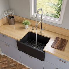 a kitchen sink sitting under a window next to a cutting board and utensils