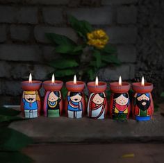 five candles are lined up in the shape of people