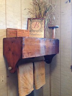 an old wooden shelf with towels hanging from it's sides and a sign on top