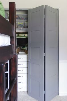 a room with a bed and two tall gray closet doors in the middle of it