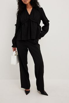 This blouse features a v neckline, long sleeves, frilled details, elasticized cuffs and a flowy fit. Elegant Black V-neck Long Sleeve Top, Chic V-neck Blouse With Elastic Sleeves, Elegant Black Long Sleeve V-neck Top, Long Sleeve Viscose Blouse With Ruffles, V-neck Blouse With Elastic Sleeves For Work, Chic Black V-neck Long Sleeve Top, Workwear Blouse With Elastic Ruffle Sleeves, Chic Black Long Sleeve Top For Work, Black Workwear Blouse With Smocked Cuffs