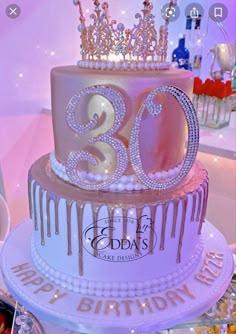 a 30th birthday cake decorated with pink icing and gold crown on the top tier