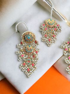 This multani work thapa kundan tikka and jhumka earrings set is gorgeous and very versatile to wear. The gold plating is traditional and the colors will match with any type of outfit. Traditional Gold Plated Cutdana Earrings, Festive Gold Plated Kundan Necklace With Latkans, Festive Kundan Bridal Earrings With Stone Work, Temple Jewelry Style Bridal Earrings With Zari Work, Festive 22k Gold Meenakari Bridal Earrings, Festive 22k Gold Bridal Earrings With Meenakari, Gold Chandbali Tikka With Zari Work, Festival Gold Plated Temple Jewelry Tikka, Kundan Bridal Earrings With Stone Work For Festive Occasions