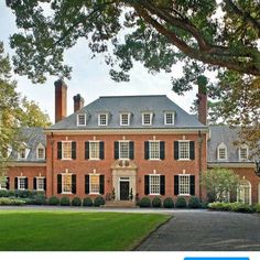 a large red brick house with black shutters