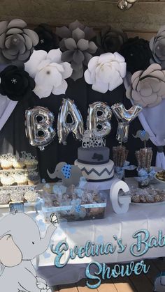 an elephant themed baby shower with balloons and cake