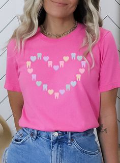 ✦ St. Patrick's Day version of this shirt: https://www.etsy.com/listing/1390930938/ Get ready to be OBSESSED with this cute tooth and candy heart Valentine shirt. Buy today for yourself or for someone special.  Q U I C K F A C T S  ✦ Unisex Bella+Canvas 3001 available in: black, charity pink, maroon, heather raspberry, and red ✦ Light fabric ✦ Retail fit/ runs true to size ✦ Printed and shipped from the USA with love  S I Z I N G  ✦ Runs true to size ✦ Solid colors are 100% cotton except Ash - 9 Pink Short Sleeve Shirt With Heart Graphic, Cute Shirt With Heart Graphic And Crew Neck, Cute Crew Neck Shirt With Heart Graphic, Valentines Dental, Tooth Shirt, Dental Shirt, Dental Shirts, Cute Tooth, Christmas Apparel