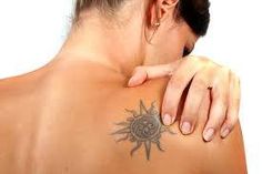 a woman with a sun tattoo on her back and shoulder is looking at the camera