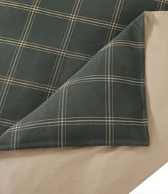 the green and beige plaid sheets are folded on top of each other