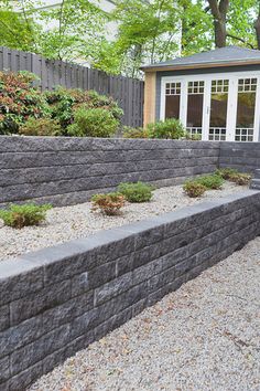 a stone wall in front of a house