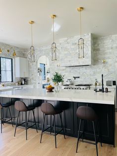 a kitchen with marble counter tops and bar stools next to an island in the middle