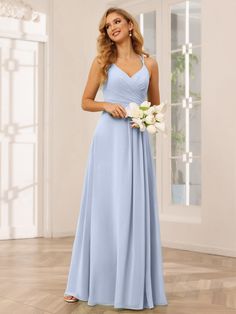 a woman in a blue bridesmaid dress standing on the floor with her bouquet