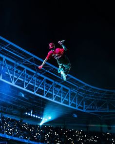 a man flying through the air while riding a skateboard in front of a crowd