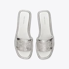 The classic sport slide, streamlined and refined. A trim band, padded in crinkled metallic leather. A slim cushioned sole for comfort and flexibility. Finished with a Double T, topstitched and oversized for a subtle statement. Luxury Slides With Textured Footbed For Spring, Casual Silver Leather Slides, Classic Slides With Textured Sole For Spring, Classic Spring Slides With Textured Sole, Silver Slides With Removable Insole, Silver Leather Slides With Cushioned Footbed, Silver Casual Slides With Cushioned Footbed, Casual Silver Slides With Cushioned Footbed, Jelly Slides