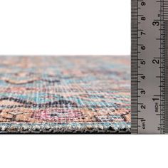 an area rug with a ruler next to it and the image of a multicolored carpet