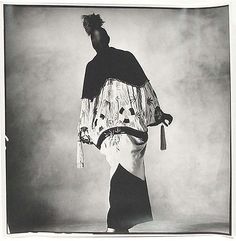 black and white photograph of a woman wearing a dress with tassels on it